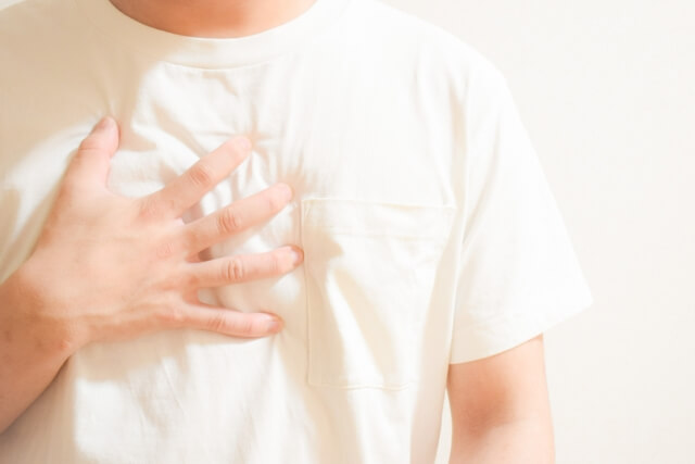 胸を押さえる男性